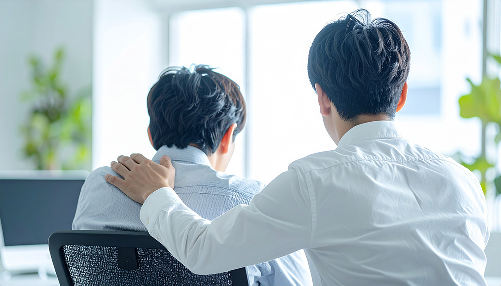 先輩が後輩を慰めるイメージ画像